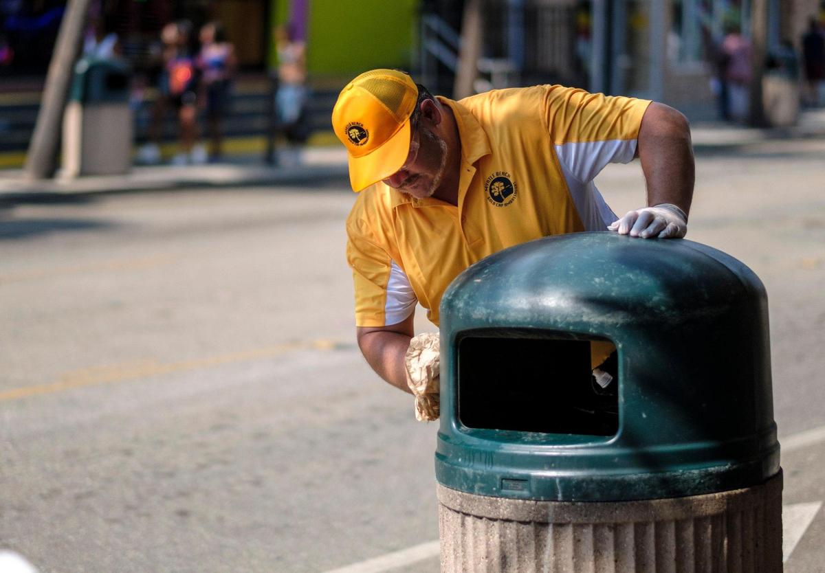 Jeremy Trendle sanitizes the surfaces of trash cans Ocean Boulevard in Myrtle Beach on Wednesday afternoon. August 26, 2020.