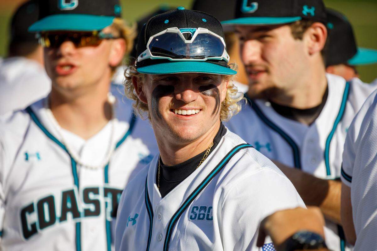 Coastal Carolina’s Dale Thomas jokes with teammates in the dug out prior to the first game of the season. CCU hosted the Baseball at the Beach Tournament at Spring Brooks Stadium in Conway Friday through Monday. Feb. 18-21, 2022.