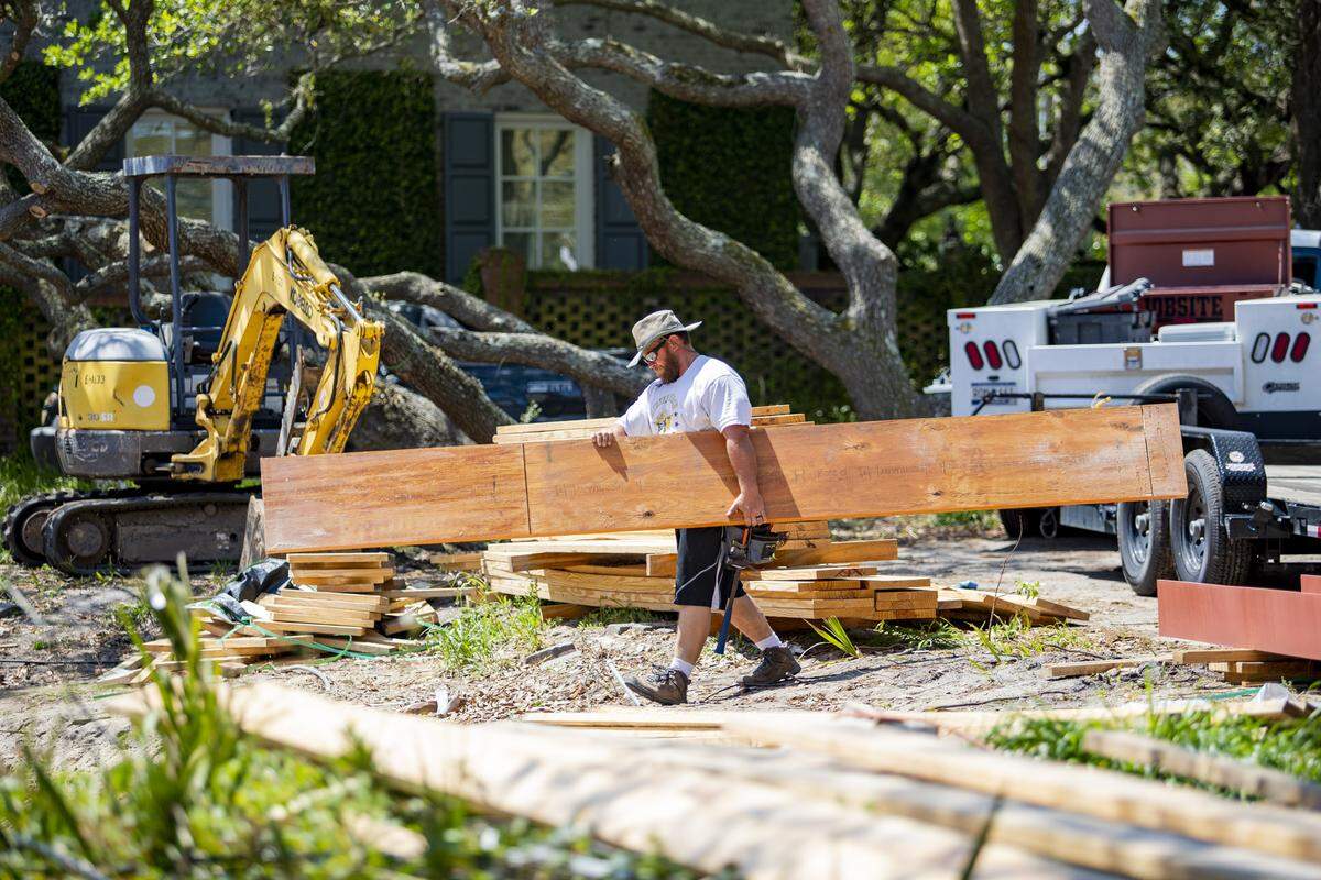 Josh Peoples of B & B Construction carries wood over to a home construction site along Ocean Boulevard Thursday afternoon in Myrtle Beach as Horry County continues to see a rise in COVID-19 coronavirus cases.