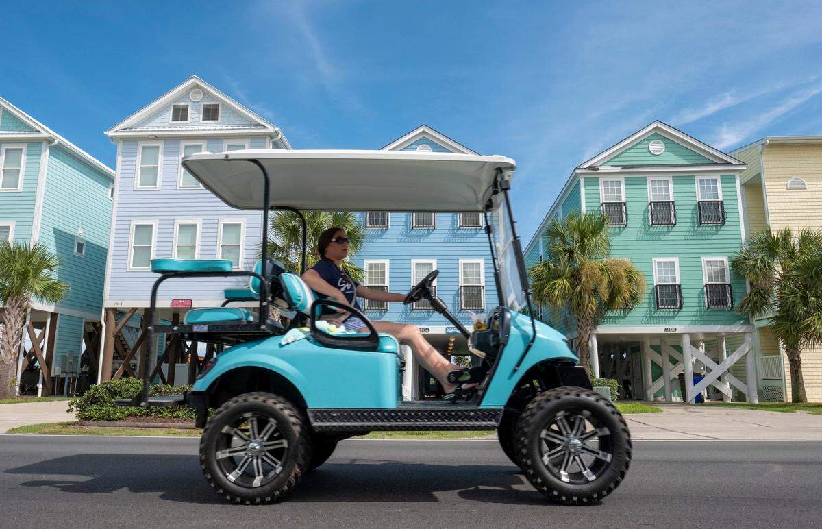 A golf cart passes colorful homes along the Ocean Boulevard in Surfside Beach, South Carolina, near Myrtle Beach. File photo.