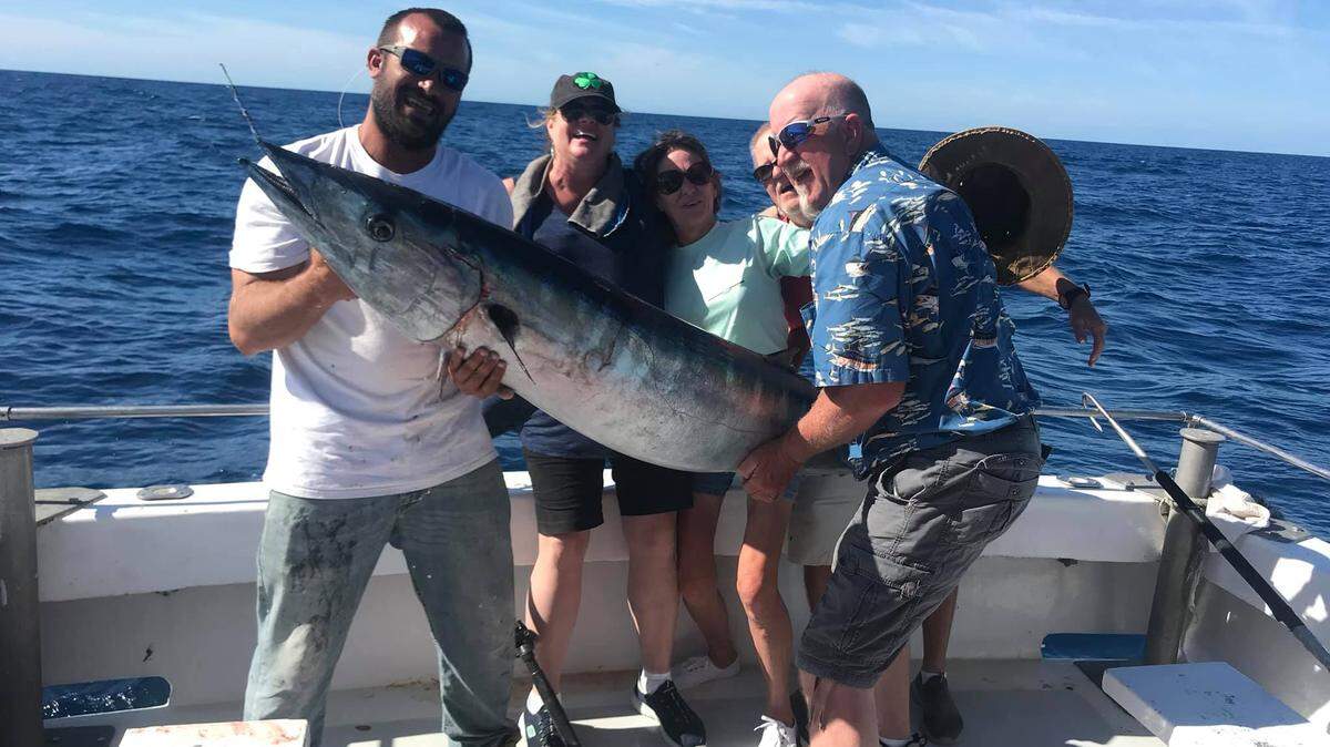 The crew of of Capt. Danny Juel’s Fish Screamer III shows off the 99.5-pound wahoo caught while bottom fishing Sunday out of Little River.