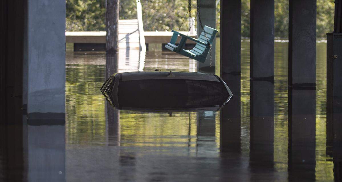 A car can be seen submerged under water underneath a carport on Pitch Landing Drive in Conway. Rising flood waters have made many homes in the southern Conway area inaccessible by car, so residents have begun launching boats to retrieve personal belongings and valuables.