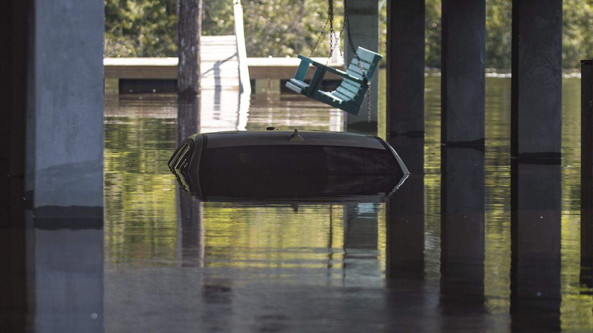 A car can be seen submerged under water underneath a carport on Pitch Landing Drive in Conway. Rising flood waters have made many homes in the southern Conway area inaccessible by car, so residents have begun launching boats to retrieve personal belongings and valuables.