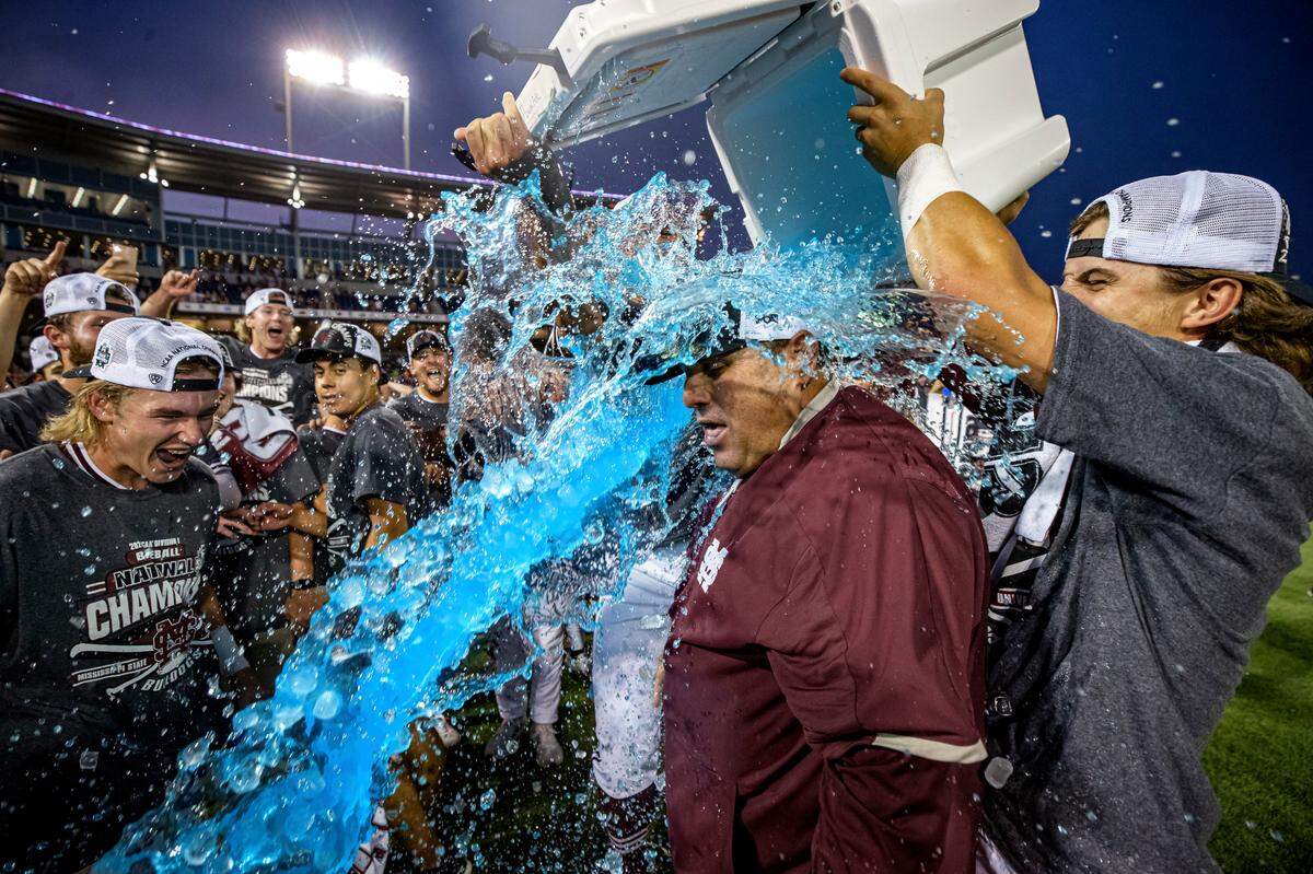A Mississippi State Bulldogs player dumps Powerade on head coach Chris Lemonis, a Socastee High graduate, after the 2021 College World Series national championship series between the Bulldogs and Vanderbilt at TD Ameritrade Park in Omaha, Nebraska.