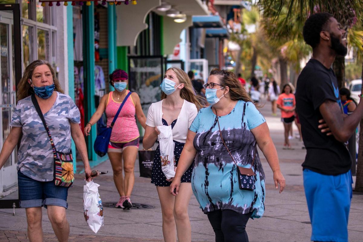 People wear mask while walking down Ocean Boulevard on Tuesday afternoon. After a busy holiday weekend in which the City of Myrtle Beach enacted mask regulations to combat the coronavirus pandemic, Ocean Boulevard and area attractions were relatively quiet on Tuesday, July 7, 2020.