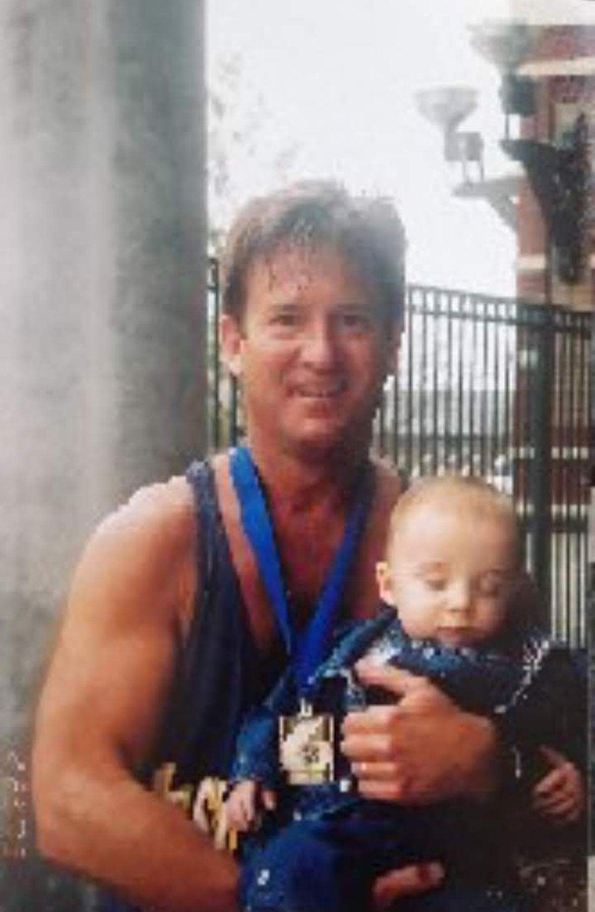 Jim Pence poses with his son Nick, who was less than a year old at the time, after he completed the 2003 Myrtle Beach Marathon.