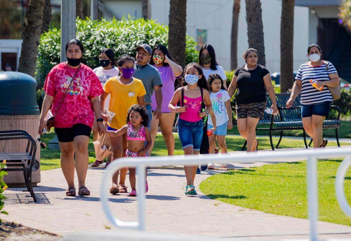 A family walks through Plyler Park Tuesday afternoon in Myrtle Beach. Coronavirus cases grew by 150 and two virus-related deaths were reported in Horry County Tuesday afternoon, according to state health officials.