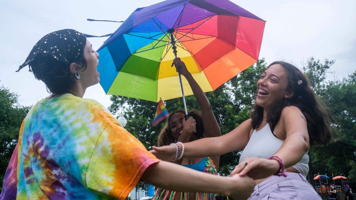 (L-R) Zoe Miller, Sieara Ekuban and Ellen Gave dance in the rain during the Grand Strand Pride event at Chapin Park. on Thursday night after the City of Myrtle Beach declared June 2022 Pride Month in Myrtle Beach. June 16, 2022.