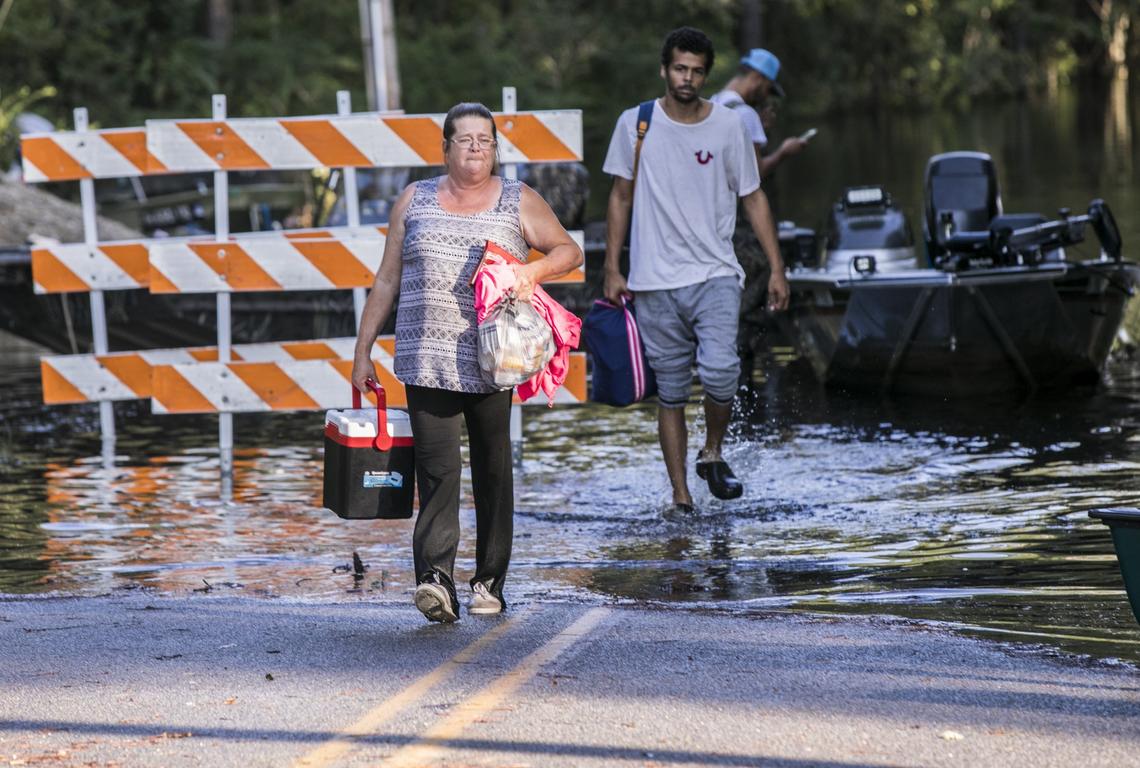Susan Dailey and her son Joshua Voaklander move belongings to dry land at Lee’s Landing Circle on Friday morning. As flood waters continue to rise to near historical levels at Lee’s Landing near Conway residents of the Waccamaw River community were making final evacuations with the help of various agencies. Friday, September 21, 2018.