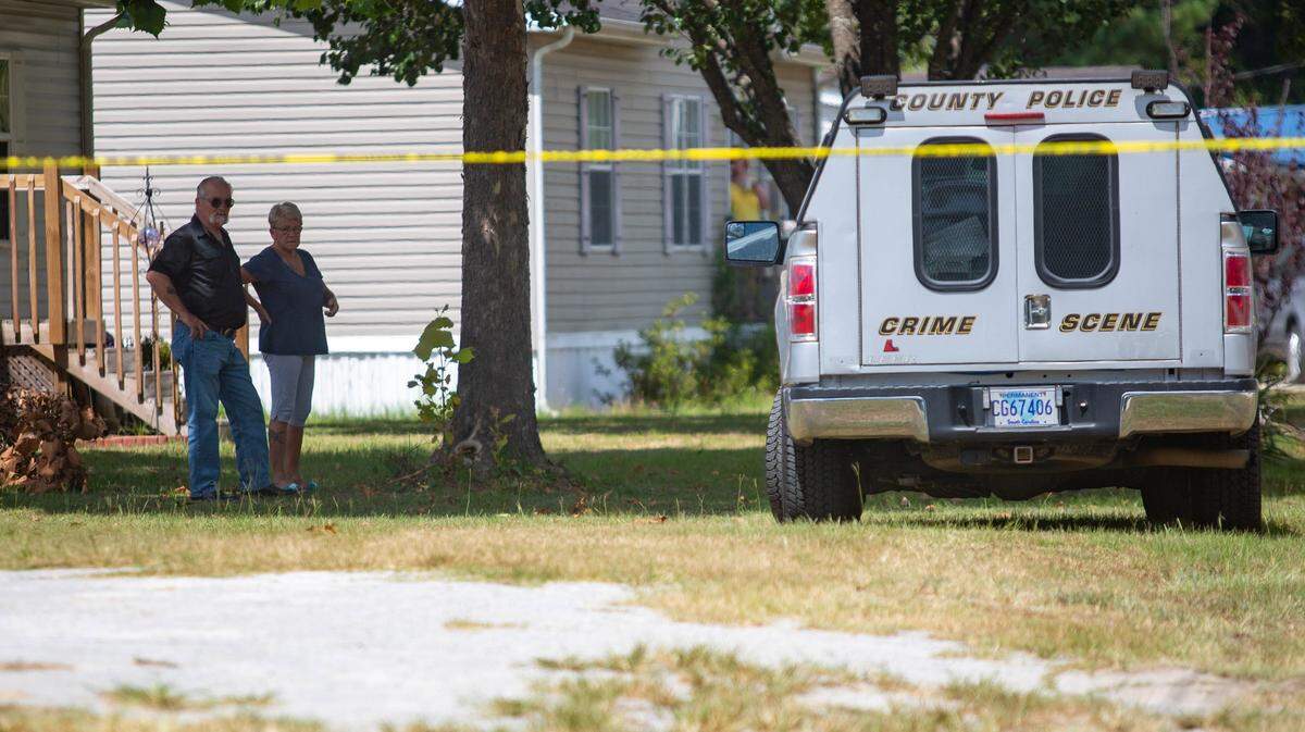 Neighbors look on as Horry County police respond to a call of a dead body on Silver Moon Ct. in Conway on Friday.