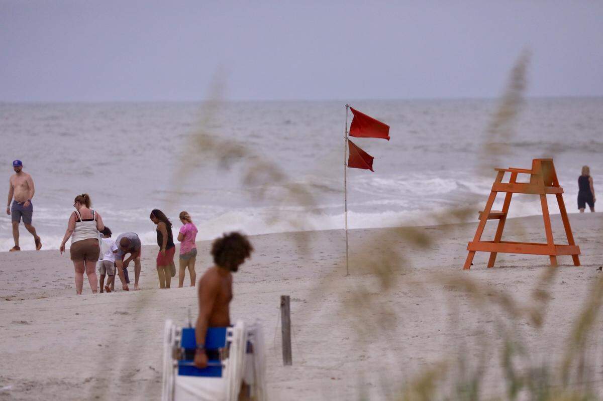 Warning flags whip in the wind ahead of Hurricane Isaias.
