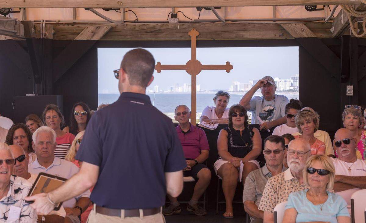Peter Copeland, associate pastor at the Apache Campground Pier church delivers a sermon to his congregants as fisherman cast from the pier in the background. July, 17 2018.