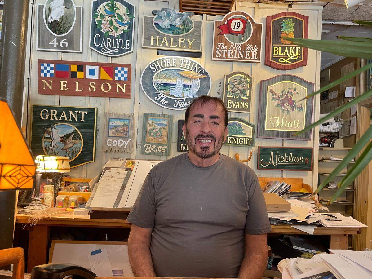 Steve Jameson sits in front of examples of residential signs he has made for beach homes in the Myrtle Beach area. Jameson is the owner of The Sign Man in North Myrtle Beach. He has been doing such work for more than 40 years. July 24, 2025.