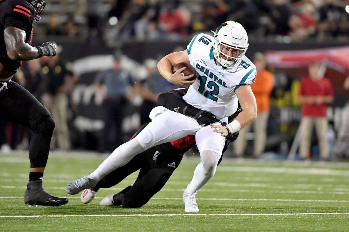 Coastal Carolina quarterback Bryce Carpenter (12) is tackled by an Arkansas State defender after a run during the first half of an NCAA college football game Thursday, Oct. 7, 2021, in Jonesboro, Ark. (AP Photo/Michael Woods)