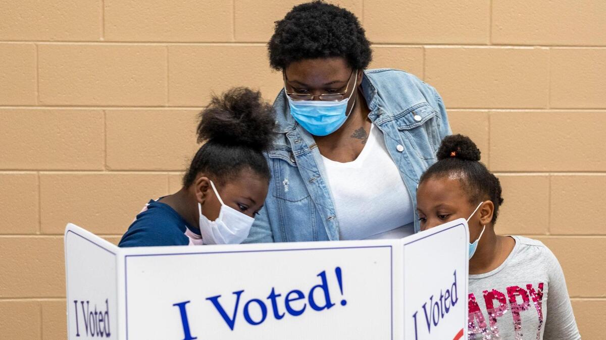 Kylinda Simmons with daughters Kymya (10) and Kyema Simmons (8) vote at the Mary C. Canty Recreation Center on Tuesday afternoon. ““With my children growing up and discussing things in school, it was a must,” Simmons said of coming out to vote today. Voters went to polling places throughout Horry County, S.C. today to vote in local and national elections. Poll workers, wearing face shields and taking precautions, reported a strong turnout of in-person voting despite concerns over the coronavirus pandemic. November 3, 2020.