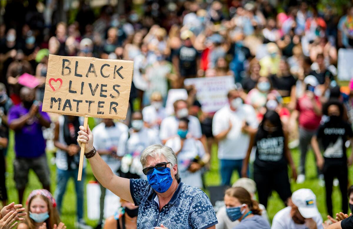 Protesters listen quietly as Conway High School graduate Cecily Hennigan performs for protesters atop a hill in Market Common’s Grand Park during a Black Lives Matter rally Sunday afternoon.