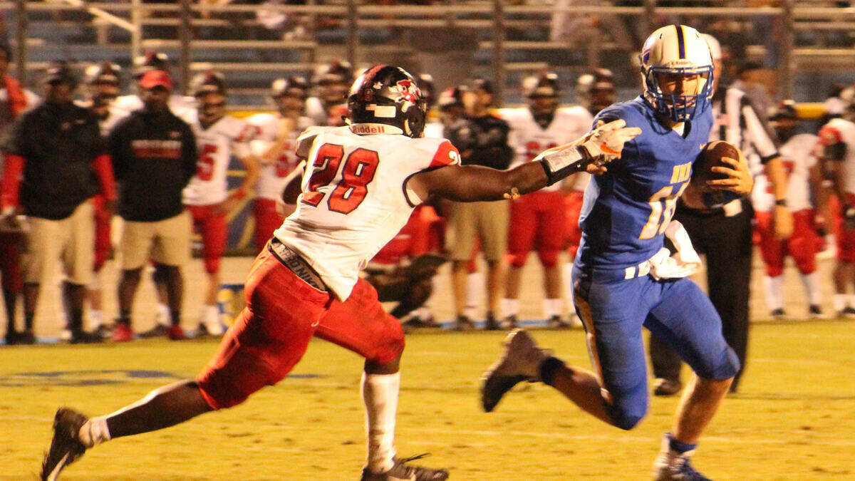 North Myrtle Beach quarterback Cason McClendon runs around Hartsville’s linebacker Kevon Haigler to set up a touchdown run on Friday, Oct. 19.