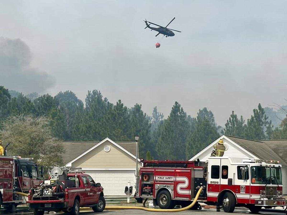 Blackhawk helicopters on Sunday, March 2, 2025, drop water on neighborhoods in the Carolina Forest area as wildfires rage across 2,000 acres. Firefighters have been battling wildfires since Saturday in the Myrtle Beach area.