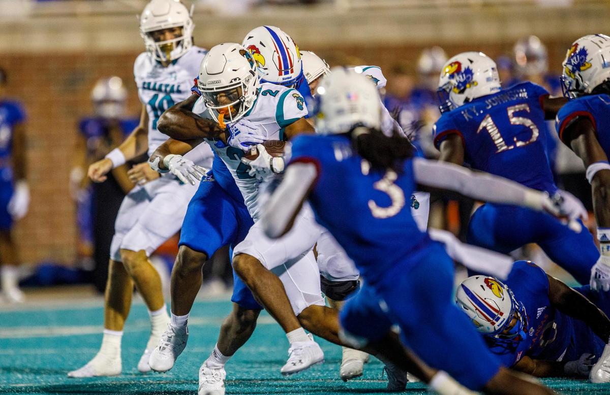 Coastal’s Reese White drags Kansas defenders down field as he rushes toward the end zone. The Coastal Carolina Chanticleers hosted Kansas at Brooks Stadium on Friday night, Aug. 11, 2021.
