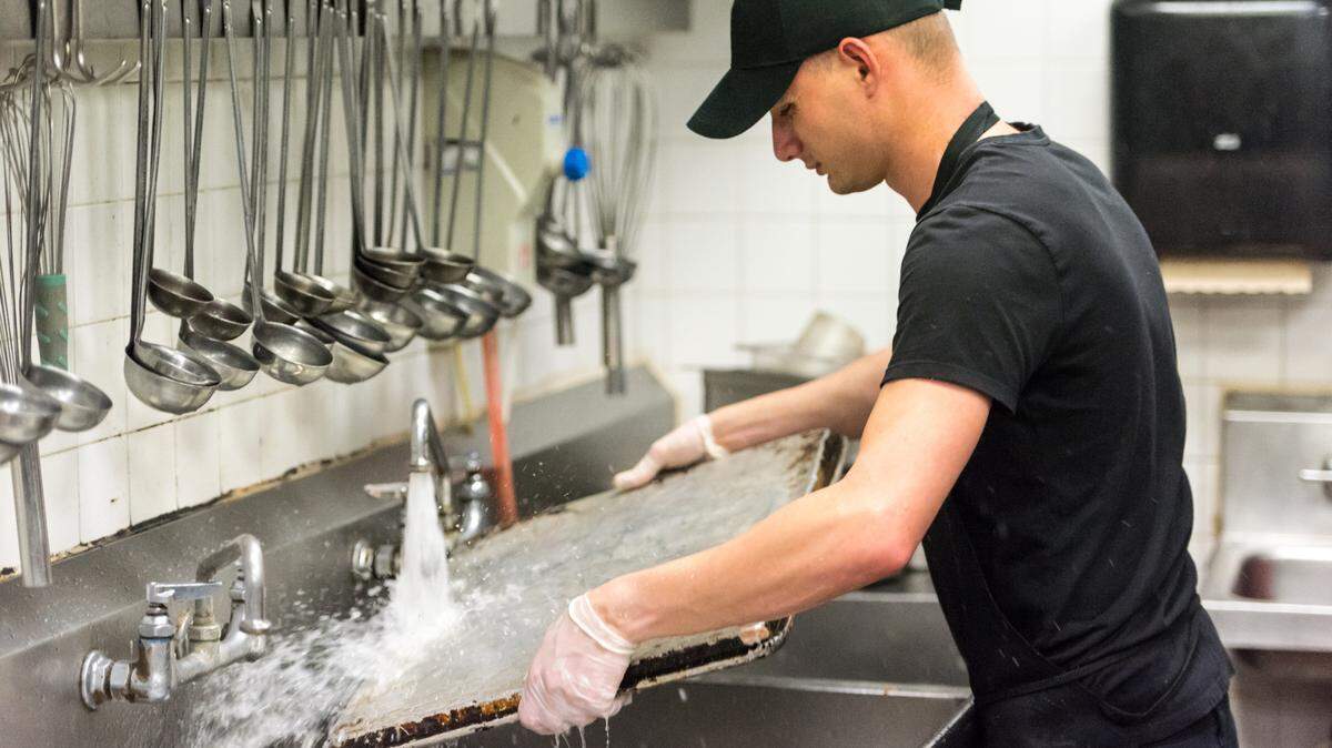 young dishwasher working at a restaurant kitchen