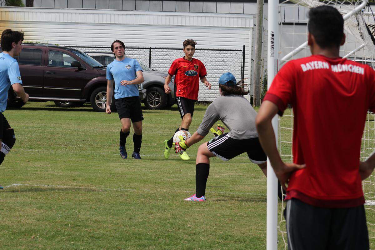 Chicago FC goalkeeper Josh Marlow, 18, blocks a shot by Legends soccer team Jared Crooks, 16, during a charity soccer tournament raising money to send soccer equipment to kids in Costa Rica and Nigeria. Legends won 7 - 1.