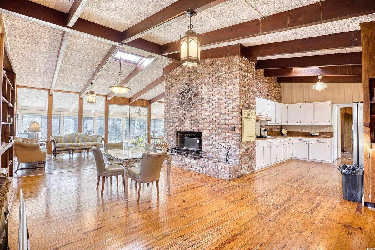 The open floor plan of the 1950s home connects the kitchen to the dining and living area. Off of the living area is a large covered porch.