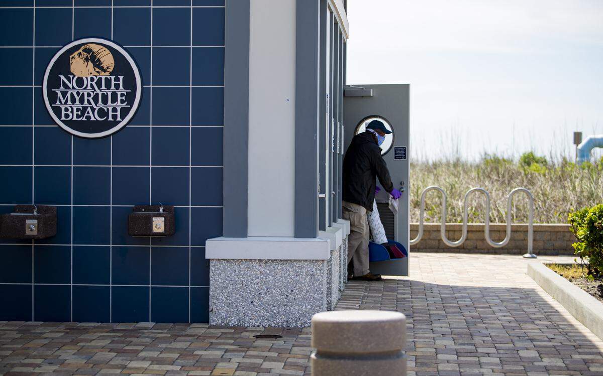 A North Myrtle Beach facilites worker cleans public restrooms at the Main Street beach access along Ocean Boulevard in North Myrtle Beach Friday morning as Horry County continues to see a rise in COVID-19 coronavirus cases.