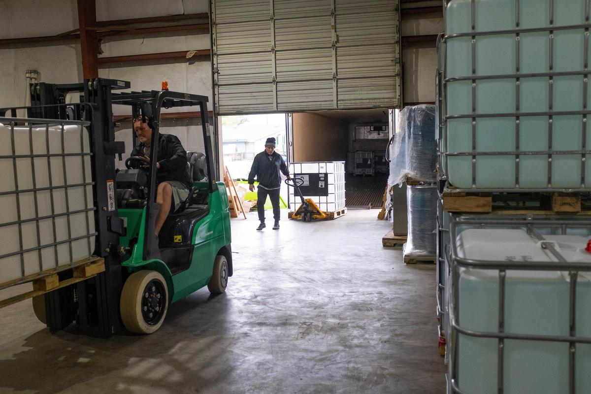 Workers at Paradigm Convergence Technologies load a truck with disinfectant to ship hospitals across the country.