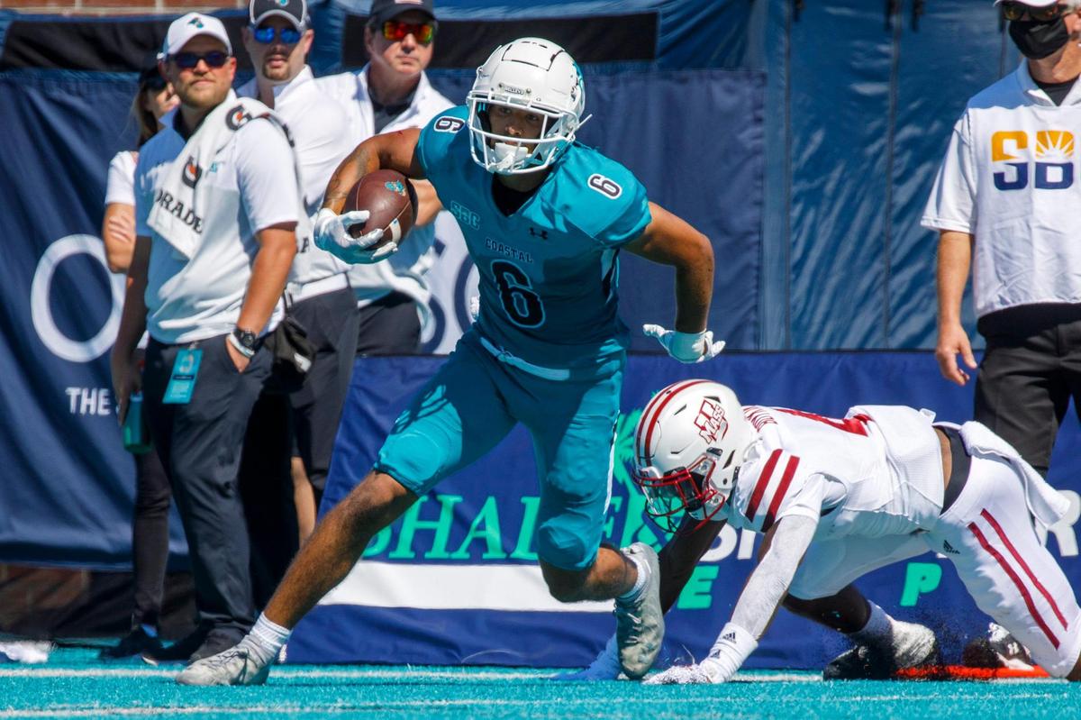 Coastal’s Jaivon Heiligh breaks a U.Mass tackle after a pass reception on Saturday, and would run in to score. Coastal Carolina, ranked 17, defeated Massachusetts on Saturday at Brooks Stadium in Conway SC. Spectators were encouraged to wear teal for a “teal out” promotion. Aug. 11, 2021.