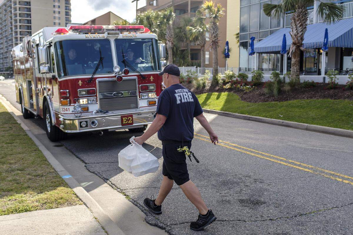 A Myrtle Beach firefighter picks up a bag of burgers from Buckets Bar and Grill. With the help of donations from their regular customers, the restaurant is passing out cheeseburger meals to Myrtle Beach firefighters. April 30, 2020