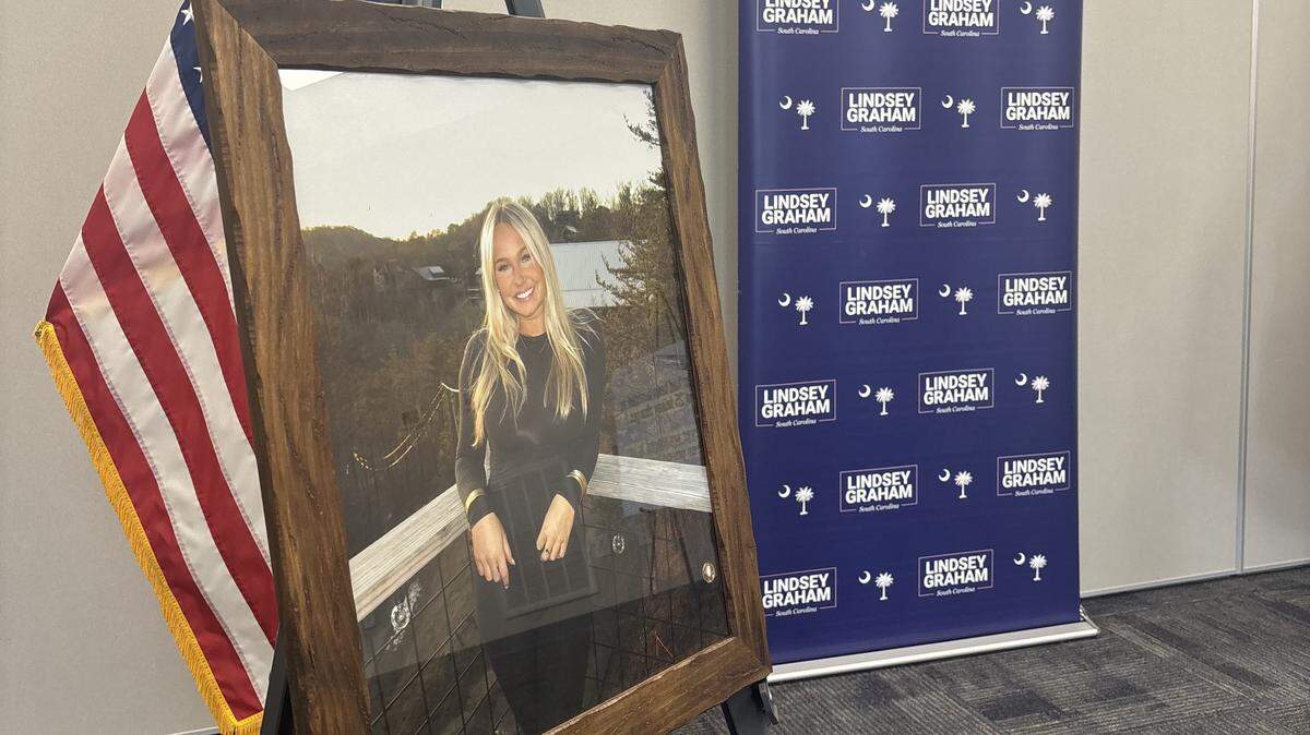 A frame containing a photo of woman with blonde hair sits on a stand.