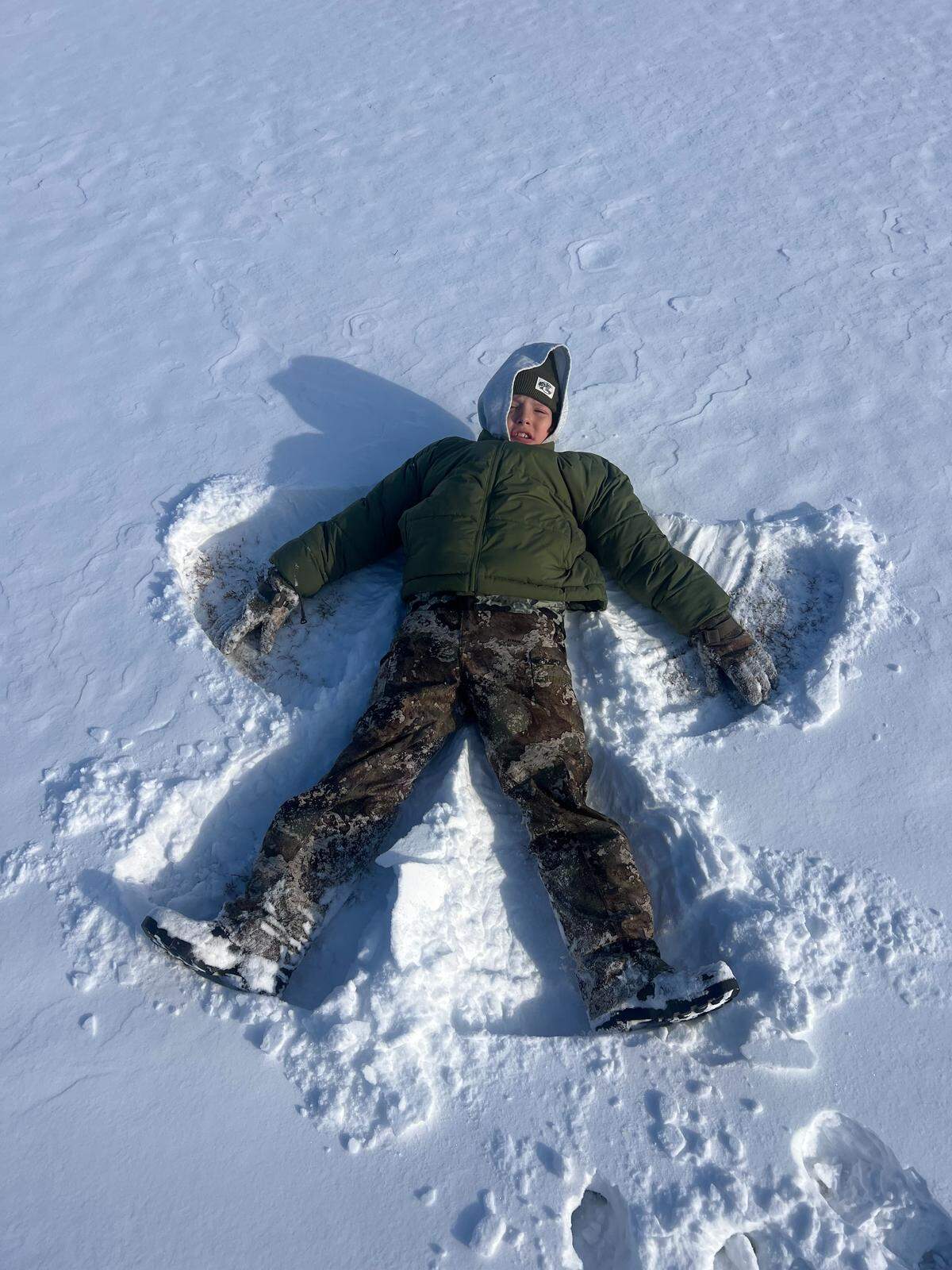 Mason Godbout makes snow angels near his Conway are home on Sunday, Feb. 1, 2026.