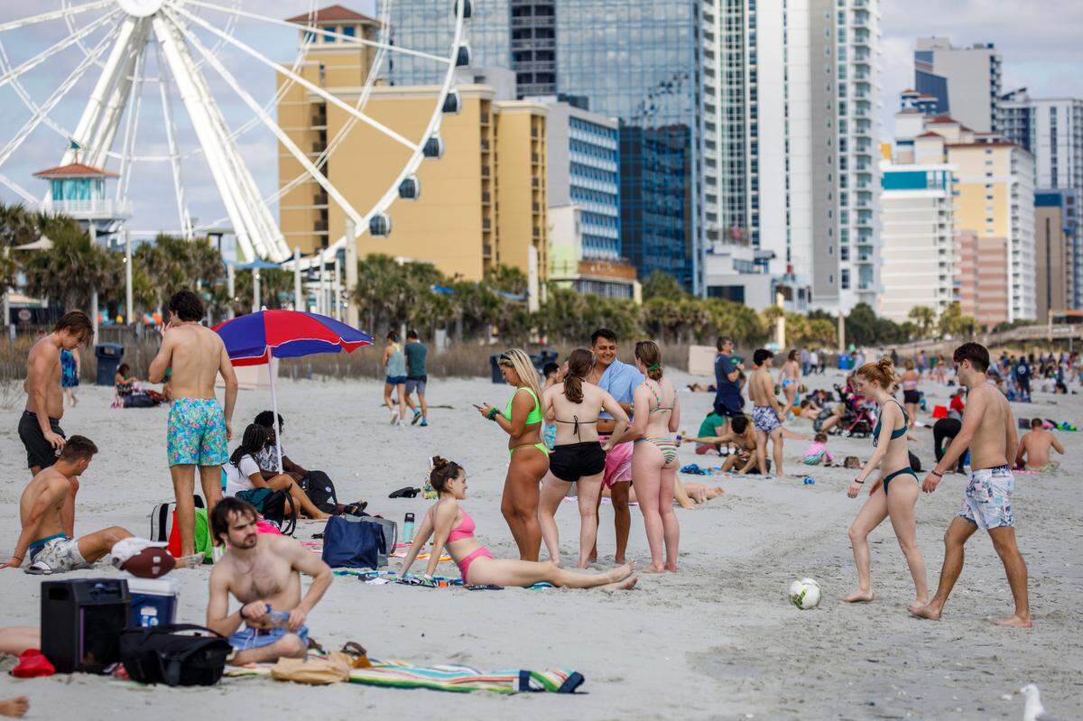 Students, most pictured from Rider University in New Jersey, play games and hang out on the beach in the downtown section of Myrtle Beach, S.C. Thousands of students visit the Grand Strand from late February to early April from Spring Break every year. March 17, 2022.