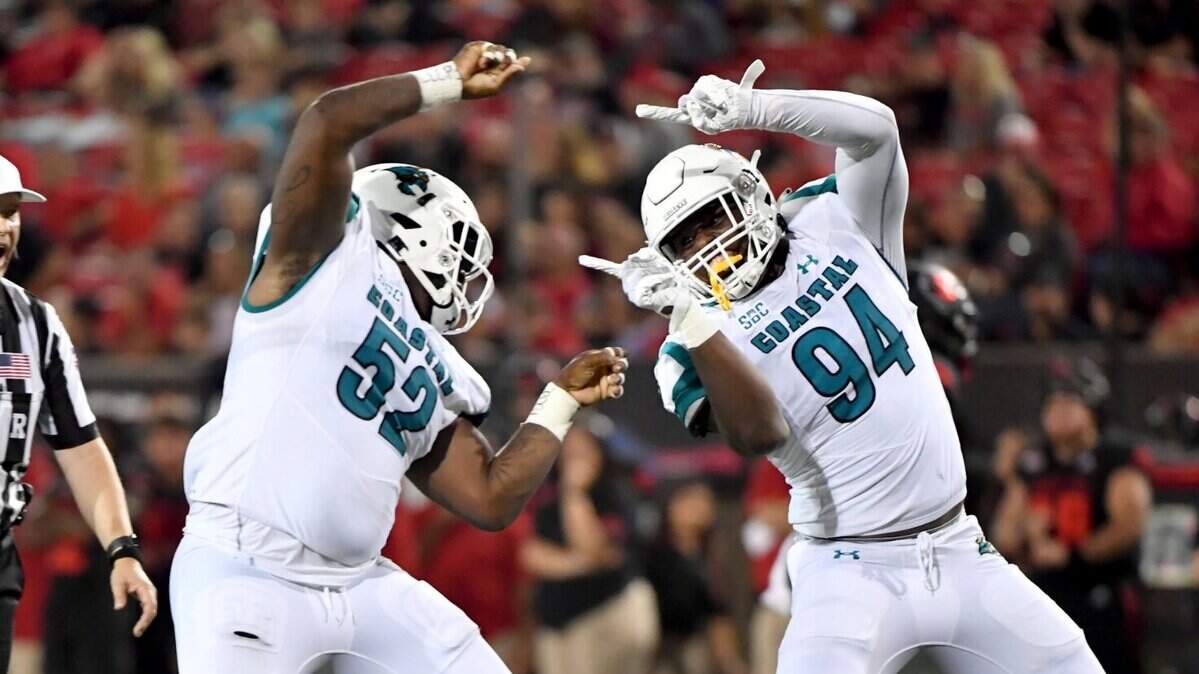 Coastal Carolina defenders C.J. Brewer (52) and Jeffrey Gunter (94) celebrate after sacking Arkansas State quarterback James Blackman during the first half Thursday, Oct. 7, 2021, in Jonesboro, Ark.