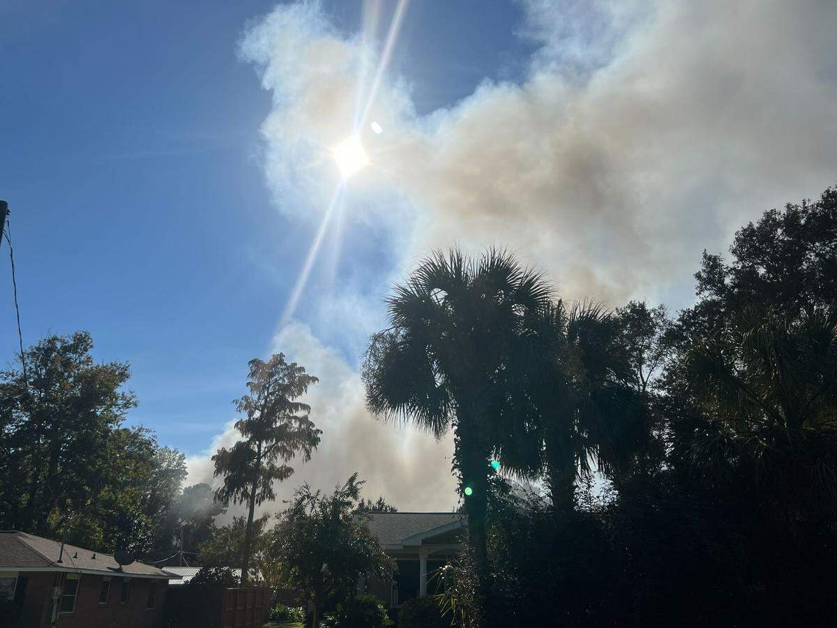 Smoke is seen drifting overhead in the area of Long Leaf Circle in Myrtle Beach, where police were handling a barricaded person who had shot at officers. The building caught on fire before the person surrendered, and the cause is under investigation, MBPD officials said.