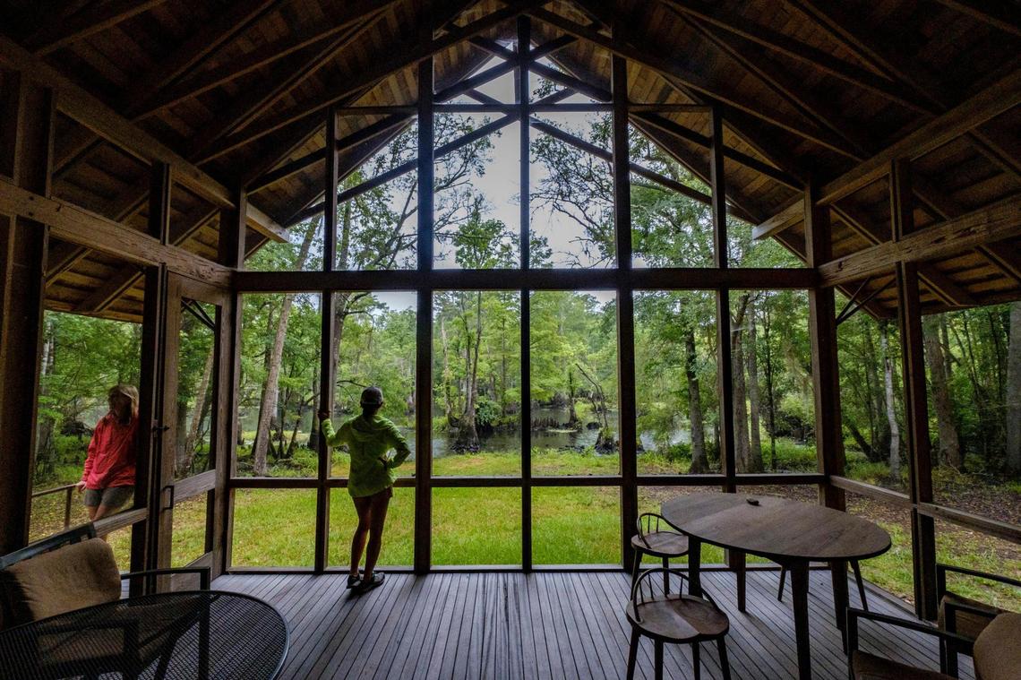 Maria Whitehead (left) and Michelle Sinkler (center), of the Land Southeast Open Space Institute stand in one of the cabins overlooking the Black River in The Black Water Cypress Preserve. The Preserve is one of twelve public and private parks along the Black River Water Trail & Park network which stretches 70 miles from Kingstree, S.C. to near Georgetown, S.C. This park is expected to serve as a model for the development of the first new state park in South Carolina in over twenty years. June 28, 2022.