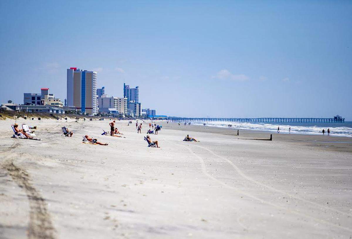 People walk along the beach Wednesday afternoon in Myrtle Beach. On Monday, April 6, South Carolina Gov. Henry McMaster issued a statewide mandate for residents to stay at home to help fight the spread of the COVID-19 coronavirus.
