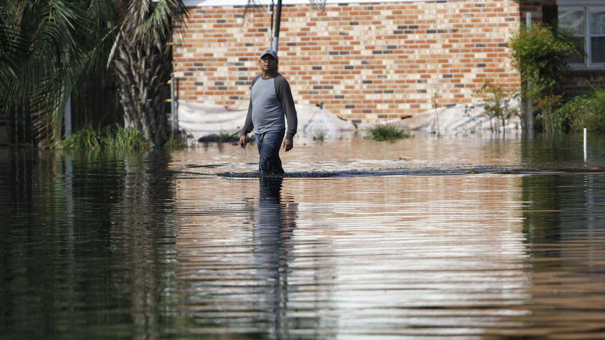 A Rosewood Estates resident walks through the water on Sept. 24, 2018.