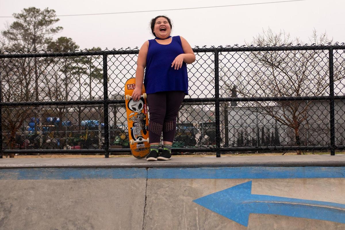 Faith Ruiz, 8, strikes a pose with her brother’s skateboard during a family trip to the park. January 25, 2021.