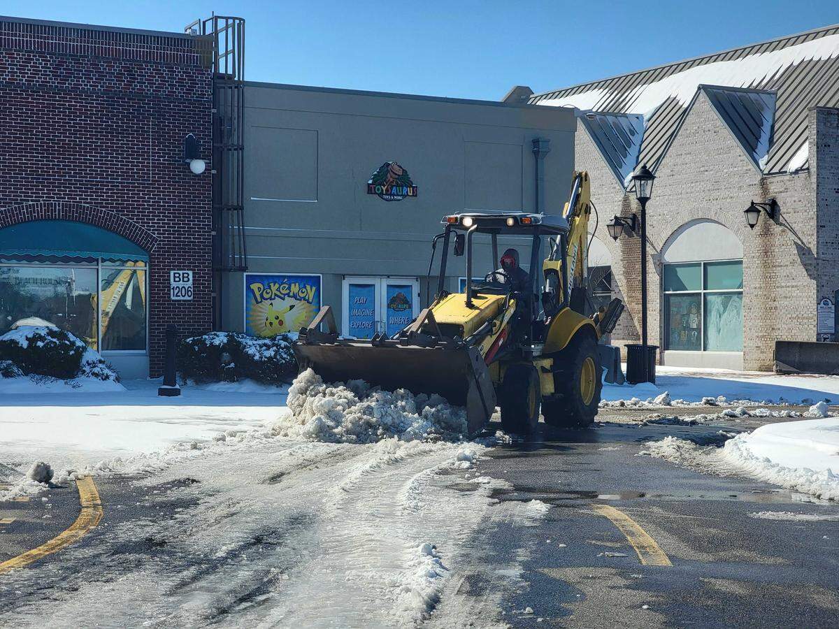 A plow clears the road and parking lots around Broadway at the Beach on Sunday, Feb. 1, 2026, after a winter bomb cyclone piled snow on Myrtle Beach.