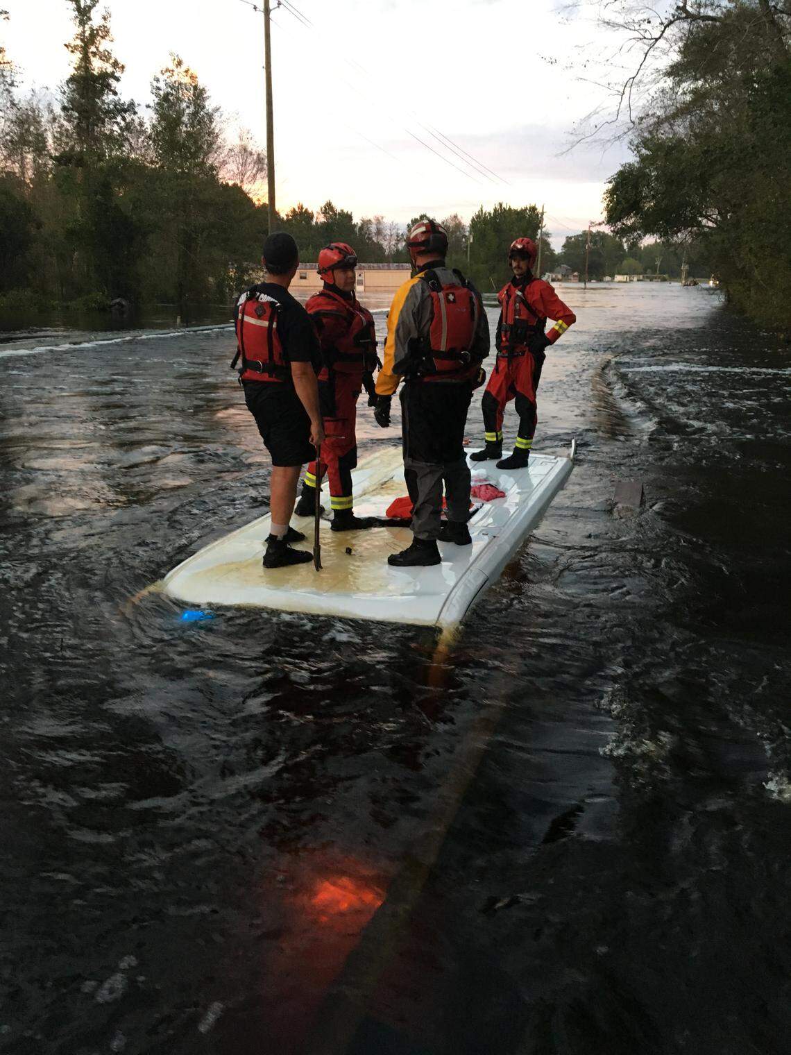 Rescue teams stand on top of a Horry County Sheriff’s Office transport van after it was swept into floodwaters on Sept. 18. Two mental health patients drown in the back of the transport.