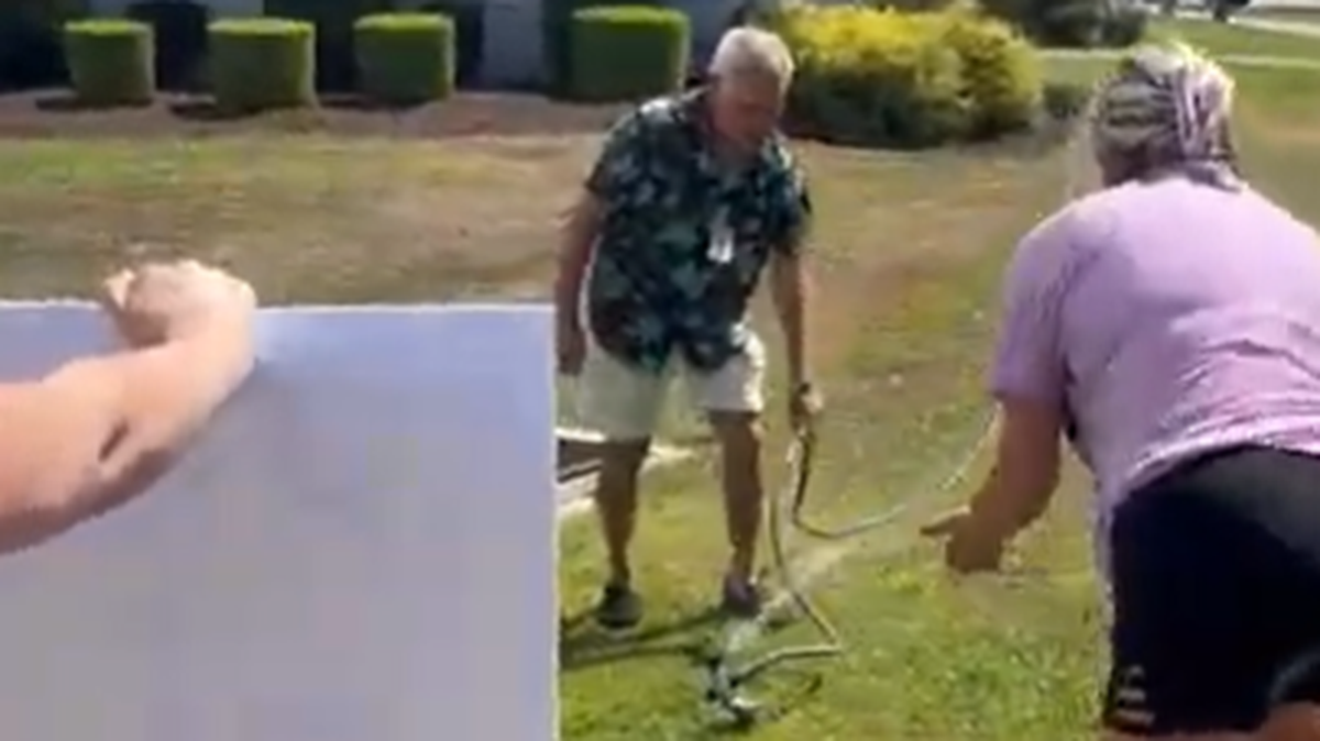 Solid Rock Church member standing in front of a sprinkler after he used it to spray water at protesters on June 30.