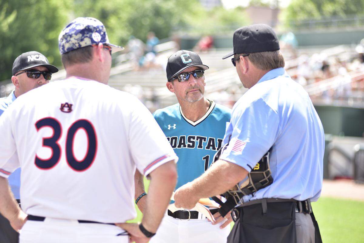 Auburn coach Butch Thompson (left) and Coastal Carolina coach Gary Gilmore meet with home plate umpire Jeff Henrichs on Friday prior to the start of CCU’s NCAA Atlanta Regional opener against Auburn at Russ Chandler Stadium in Atlanta.