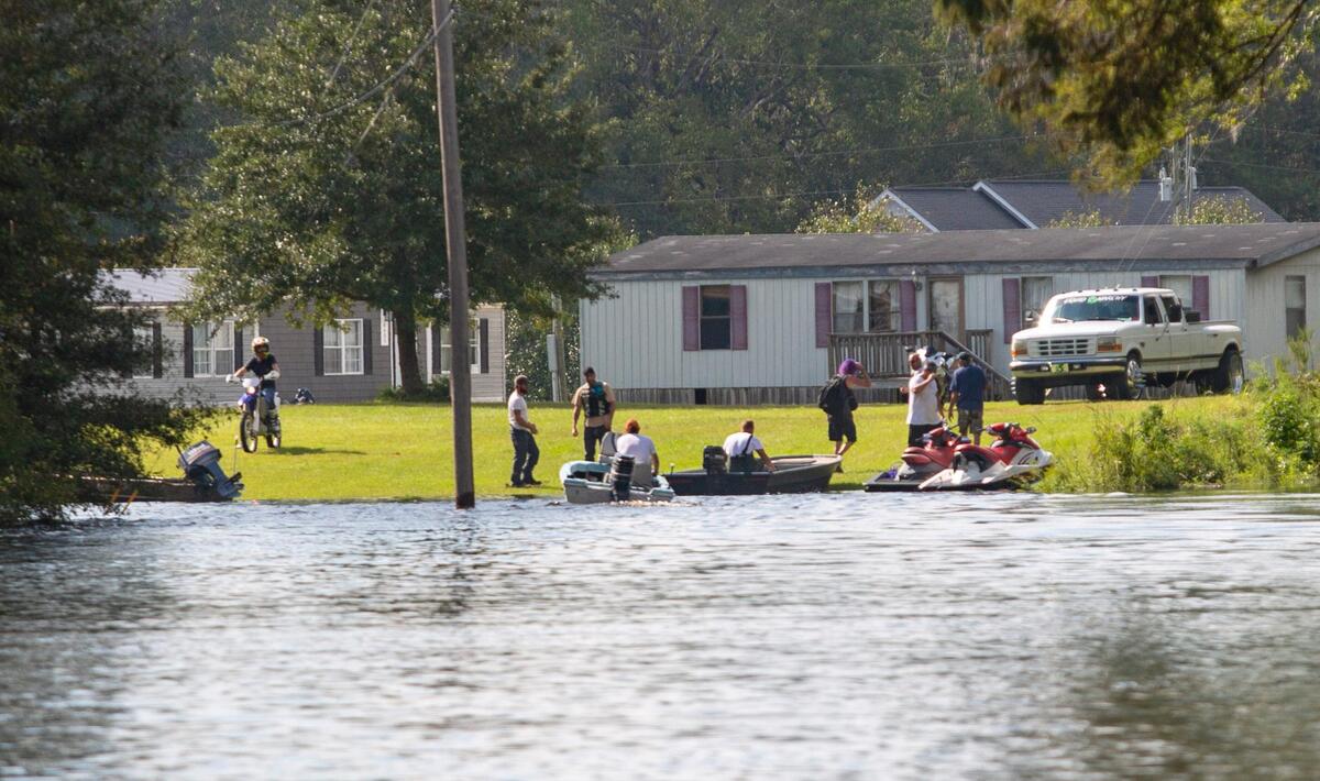 Peachtree Landing residents travel by boat and jet skis to assess damage and check on their homes Tuesday.