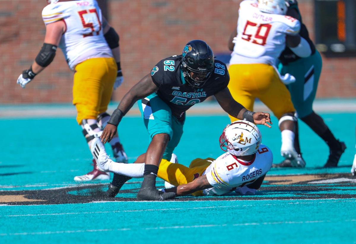 Coastal’s C.J. Brewer knocks down ULM quarterback Chandler Rogers just as he releases an incomplete pass on Saturday. The No. 16 Coastal Carolina University Chanticleers college football team defeated Louisiana-Monroe Warhawks Saturday at Brooks Stadium in Conway, SC. Oct. 2, 2021.