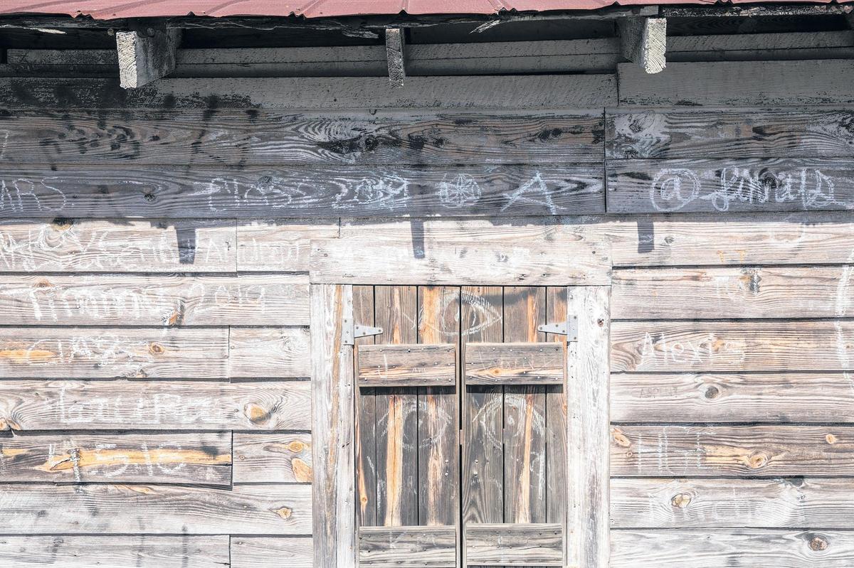 Graffiti messages on the river front side of the Jerry Cox Warehouse building along the Conway riverfront - Aug. 8, 2018.