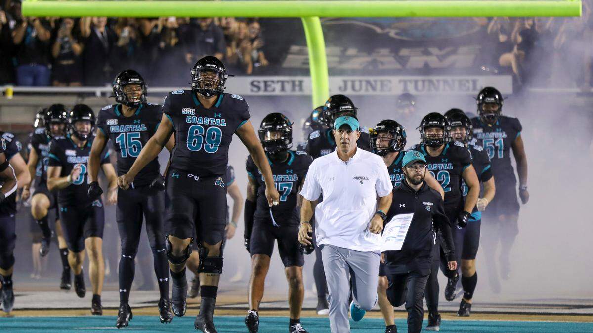 Coach Jamey Chadwell leads his team onto the field at Brooks Stadium. The Coastal Carolina Chanticleers beat rival Appalachian State 35-28 in front of a record crowd at Brooks Stadium Thursday night. November 3, 2022.