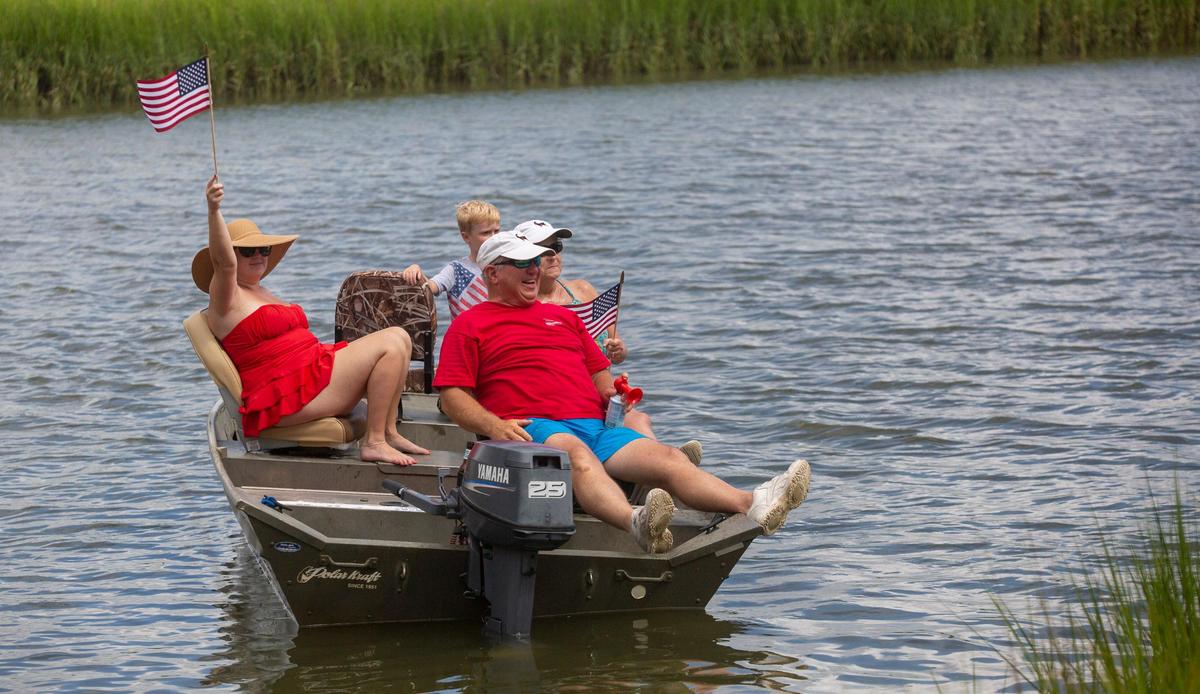 Parade attendees watch from the marsh as floats move by during the 2018 Pawleys Island 4th of July Parade.