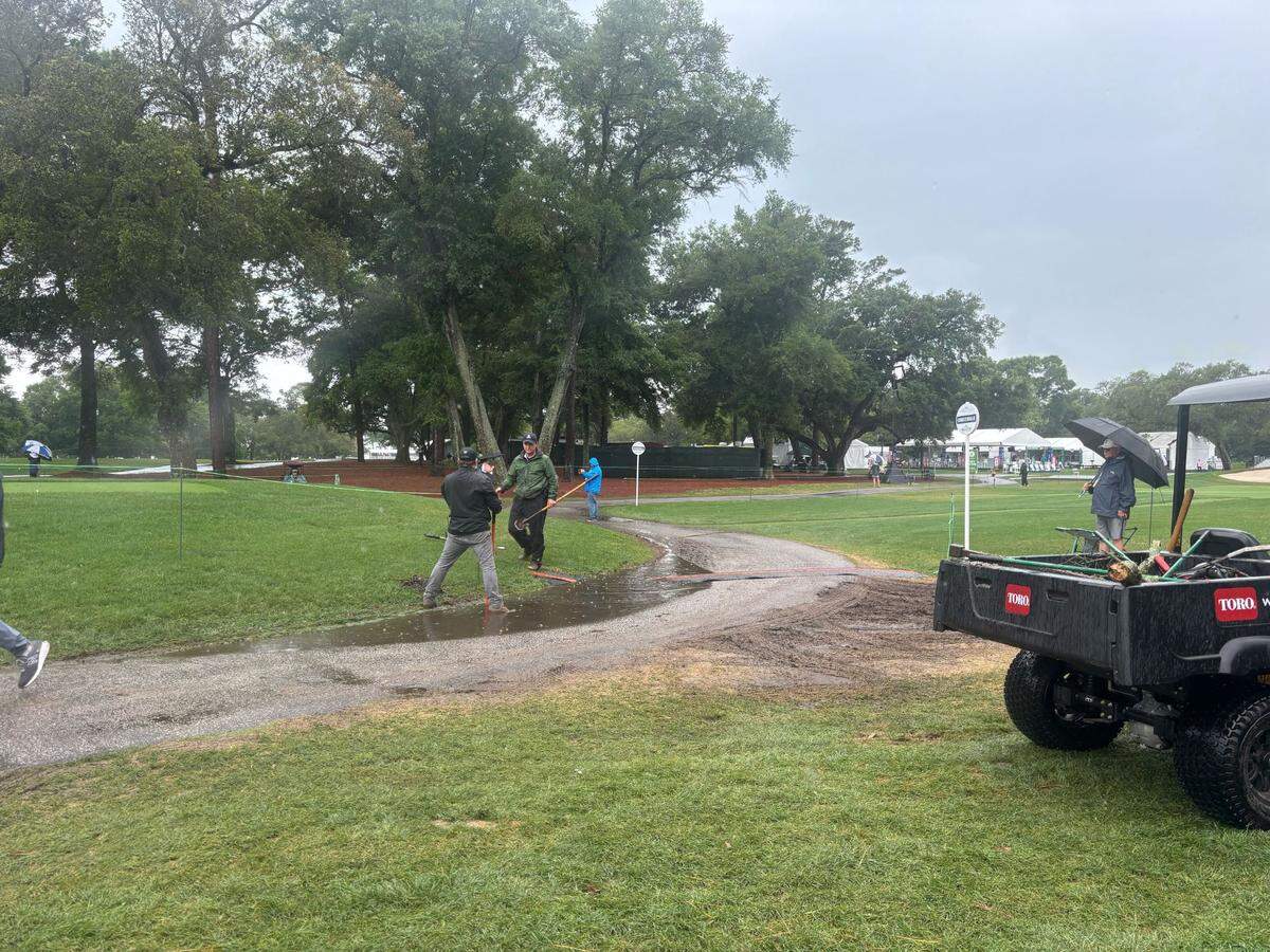 Dunes Golf and Beach Club staff work to clear puddles as rain hits the course during the Myrtle Beach Classic PGA Tournament on Sunday.