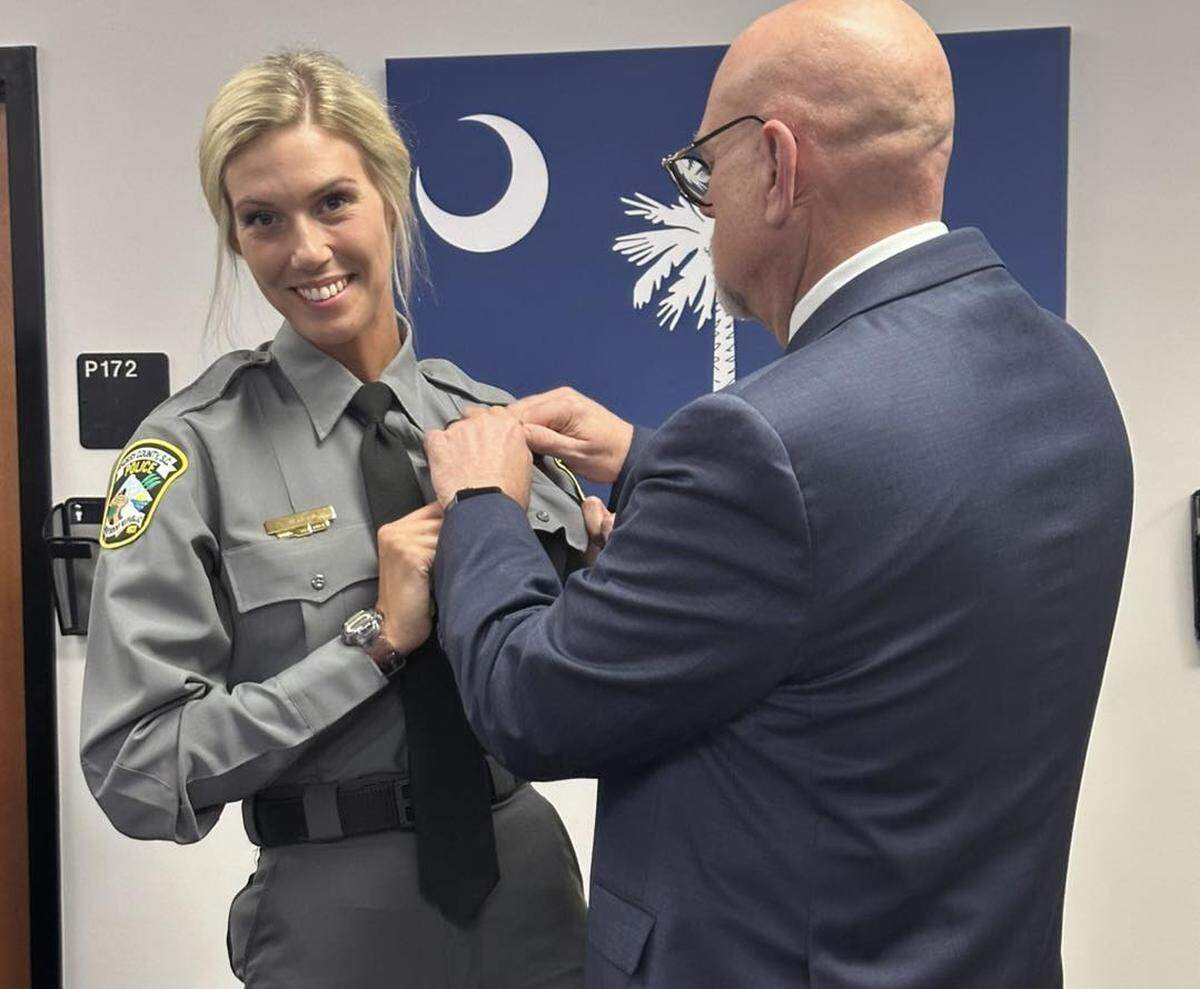 Randy Webster, Horry County deputy administrator for public safety, pins Investigator Kelsey Manemeit during a May 2025 swearing-in ceremony. Webster announced his retirement Oct. 20, shortly after Manemeit reportedly filed a sexual harassment complaint against him. Manemeit was later among four officers forced to resign Nov. 6 for alleged sexual relationships with co-workers.